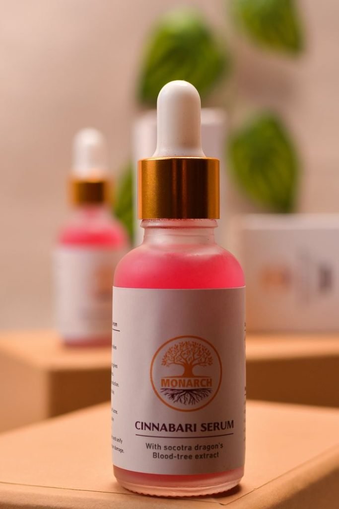 Close-up of a Cinnabari serum bottle with Socotra dragons blood-tree extract on wooden surface.